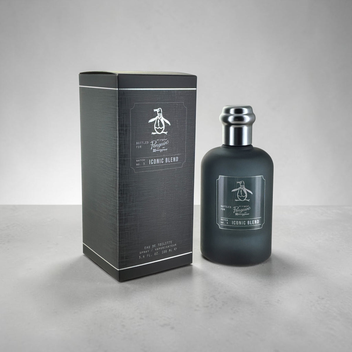 "Iconic Blend Original Penguin fresh spicy woody cologne for men, bottle next to its packaging"