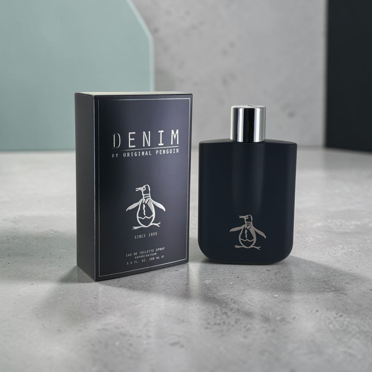 "Denim Original Penguin fresh spicy-citrus cologne for men, bottle next to its packaging"